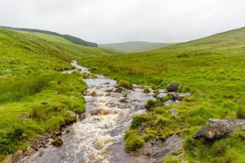 A river flowing through hilly scenery
