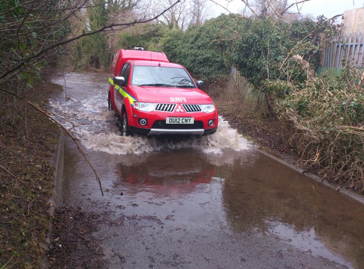 Fire truck moving through flooded lane